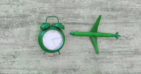 green alarm clock on green wooden background