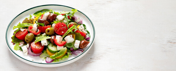 Greek village salad horiatiki with feta cheese, olives, cherry tomato, cucumber and red onion, vegeterian mediterranean food, low calories dieting meal.