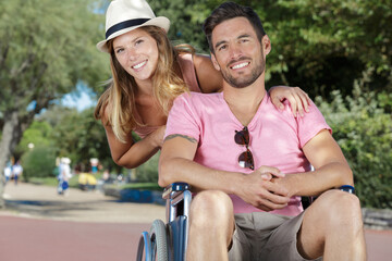 Fototapeta premium young couple in wheelchair strolling in the park