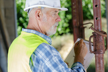 senior man in a construction helmet outdoors