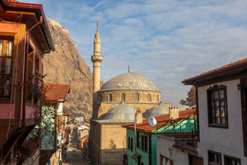 Obraz premium Afyonkarahisar, Turkey, January 20, 2023: Street with traditional turkish ottoman houses in Afyonkarahisar old town. Afyonkarahisar cityscape Afyon castle on the rock, 