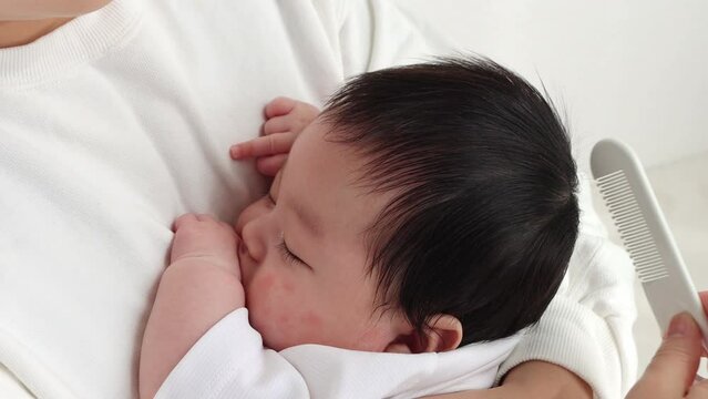 赤ちゃんの髪を櫛で梳くイメージ（0歳2か月、日本人、男の子）