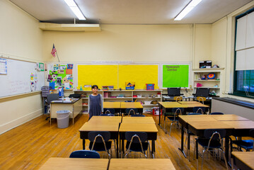Young asian girl standing in elementary school classroom