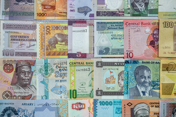 close-up of African currency of various colors shapes  denominations filled the entire table.