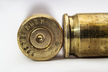 two machine gun cartridge cases on color gradient background close up