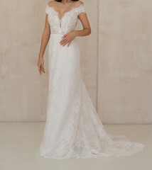 Front view of beautiful bride dressed in a white long classic wedding dress. Gorgeous wedding sleeveless dress decorated with lace. Wedding lacy corset with deep neckline