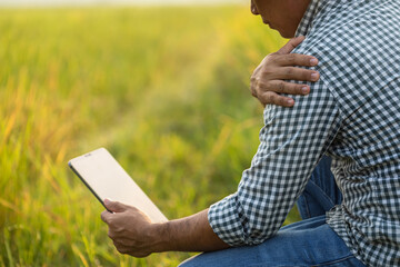 Injuries or Illnesses, that can happen to farmers while working. Man is using his hand to cover over elbow because of hurt,  pain or feeling ill.