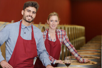 smiling female and male worker in a wine cellar