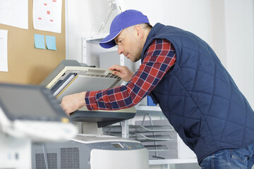 technician repairing an office photocopier