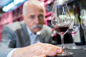 senior man enjoys drinking wine