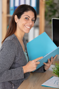 portrait of smiling pretty young business woman holding clipboard