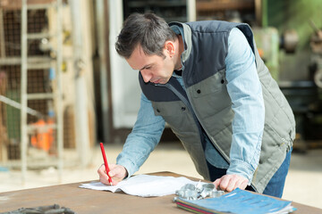 engineer writing notes on factory