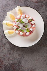 Herring salad or Sillsallad traditional dish of Scandinavian cuisine close-up in a plate on the table. vertical top view from above