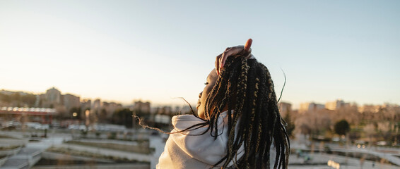 young african american woman, with dreadlocks, from behind contemplating the city - rear view -