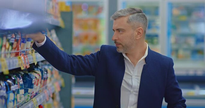 married man shopping alone in supermarket, choosing groats in grocery store, portrait, 4K, Prores