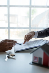 Young Asian home sales agents, insurance agents, and real estate agents offer young Asian entrepreneurs information on price conditions when signing a contract to buy rent house in the office.