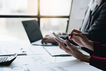 A group of Asian businessmen is meeting to discuss financial income in a real estate project. There is an evaluation calculation with a team of financial advisors to analyze with investors.