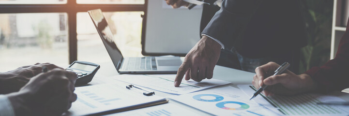 A group of Asian businessmen is meeting to discuss financial income in a real estate project. There is an evaluation calculation with a team of financial advisors to analyze with investors.