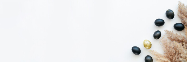 Eggs painted gold and black on white background. Minimal Easter concept with copy space for text. Golden luxury backdrop