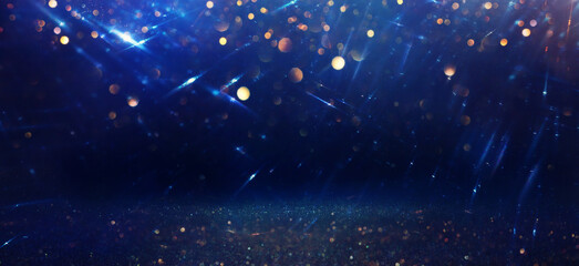 background of abstract glitter lights. gold, blue and black. de focused