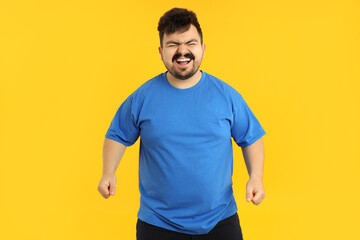 Concept of people, young fat man on yellow background