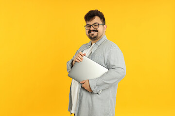 Concept of people, young fat man with laptop on yellow background