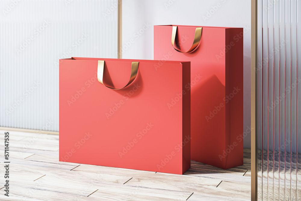 Poster perspective view on blank red paper shopping bags with space for your brand name or text on wooden f