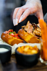woman chef hands in gloves cooking sandwich Set bruschetta with tuna, cheese, roastbeef, vegetables and french fries on kitchen