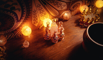 A closeup of perfumes bottles in candlelight.