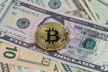 Golden bitcoin coin on a paper dollars money