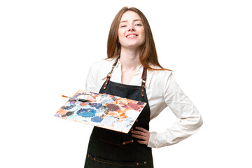 Young artist woman holding a palette over isolated chroma key background posing with arms at hip and smiling