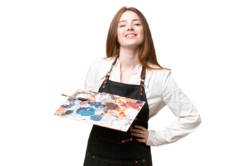 Young artist woman holding a palette over isolated chroma key background posing with arms at hip and smiling