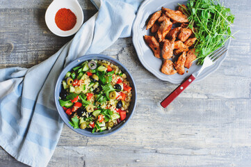 arabian or morrocan cuisine - tabule spicy bulgur salad with olives, bell peppers, cucumbers and grilled chicken breast