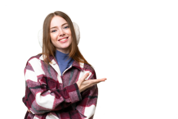 Young pretty woman wearing winter muffs over isolated chroma key background presenting an idea while looking smiling towards