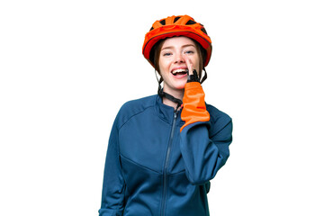 Young cyclist woman over isolated chroma key background shouting with mouth wide open