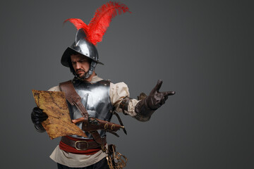 Studio shot of isolated on gray background conquistador with map. - obrazy, fototapety, plakaty