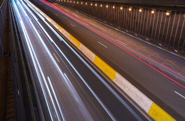 Wide angle long exposure photo with rush hour traffic at the entrance of an underground tunnel during the night. Traffic infrastructure image.