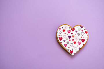 Gingerbread heart. Spring mood. Pastel colors. Delicious gingerbread on a light lilac color background. Sweet treats for lovers. Heart-shaped honey cake. 