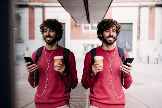 Happy Man With Smart Phone And Coffee Cup Standing At Footpath