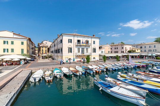 Italy, Veneto, Bardolino, Rows of boats moored in town harbor