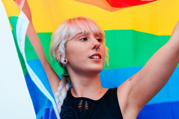 Lesbian woman with the flag of pride in sportswear at gay parade