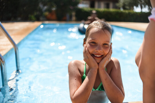 Sisters swimming in the pool. Looking at the frame