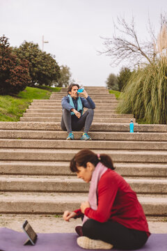 Happy mature woman using tablet PC with man sitting in background