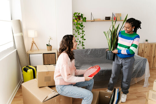 Excited friends unpacking box at home