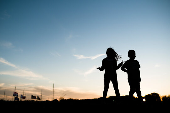 Silhouetted Children standing with peace sign in Waco Texas