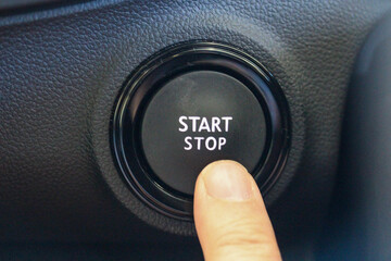 Finger pressing a Start Stop button