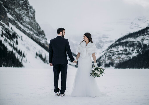 bride and groom wedding on ice in winter Lake Louise, Alberta, Canada