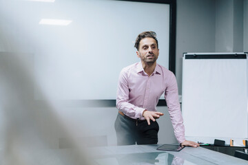 Mature businessman giving presentation in meeting room at office