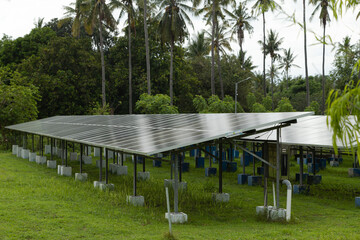Solar power plant energy panels on tropical island Gili Air, Indonesia. Cloudy day, tropical forest