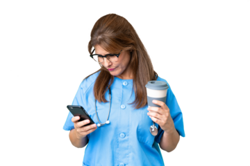 Middle age nurse woman over isolated background holding coffee to take away and a mobile